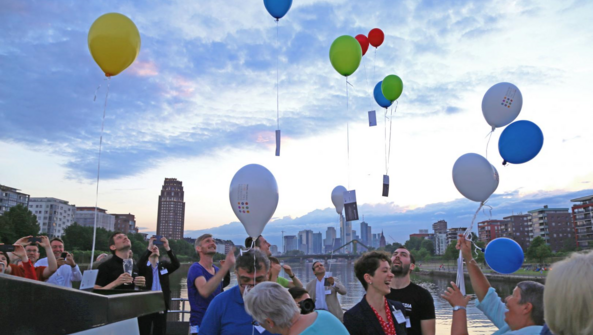 Viele Menschen stehen auf einem Schiff und lassen ihre Ballons in die Luft schweben.