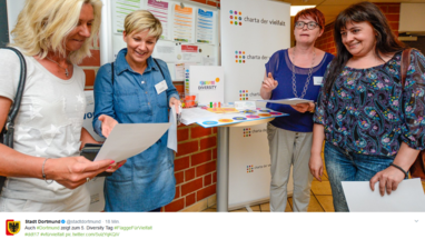 Vier Frauen stehen an einem Infostand, bei dem es um das Thema Vielfalt geht.