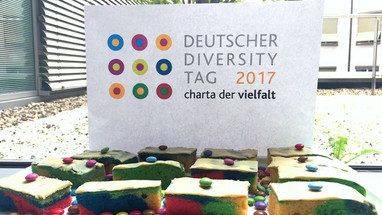 Auf dem Tisch liegen Regenbogen Kuchen mit dem Flyer zum DDT17.